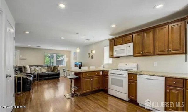 106 Manalapan Rd, Spotswood, NJ 08884 - kitchen with white appliances, a peninsula, open floor plan, a kitchen breakfast bar, and brown cabinetry