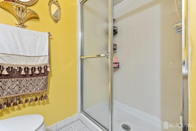 bathroom featuring toilet and an enclosed shower