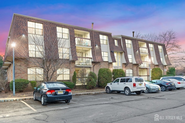 property at dusk with uncovered parking