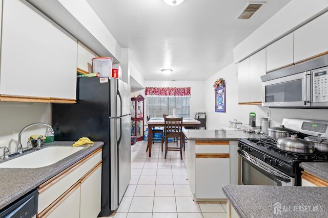 1006 Hidden Village Dr, Perth Amboy, NJ 08861 - kitchen featuring stainless steel appliances, a sink, light tile patterned floors, white cabinetry, and a peninsula