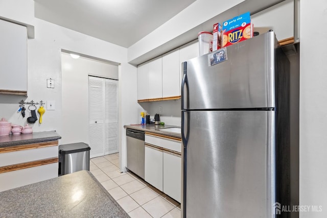 1006 Hidden Village Dr, Perth Amboy, NJ 08861 - kitchen featuring stainless steel appliances, white cabinets, light tile patterned floors, and dark countertops