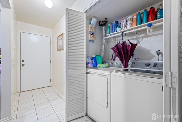 laundry area featuring washer and clothes dryer and light tile patterned flooring