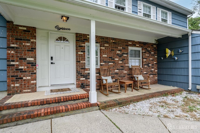 18 Chipper Dr, South Brunswick, NJ 08824 - doorway to property featuring a porch and brick siding