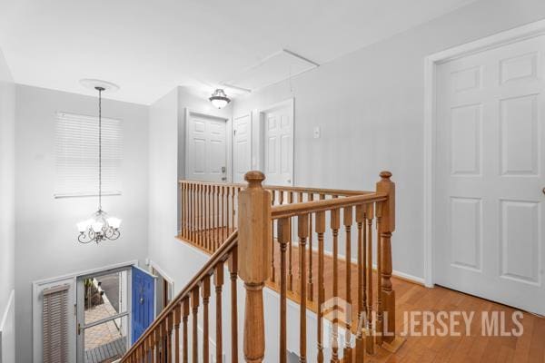 54 Magellan Way, Franklin Twsp, NJ 08823 - hallway with an upstairs landing, attic access, wood finished floors, a chandelier, and baseboards