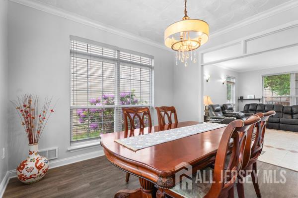 54 Magellan Way, Franklin Twsp, NJ 08823 - dining space featuring a chandelier, baseboards, ornamental molding, and wood finished floors