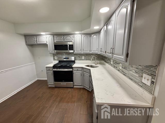 3605 Riddle Ct, Bridgewater, NJ 08807 - kitchen with appliances with stainless steel finishes, tasteful backsplash, light countertops, gray cabinets, and dark wood-type flooring