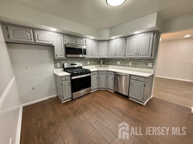 3605 Riddle Ct, Bridgewater, NJ 08807 - kitchen with appliances with stainless steel finishes, gray cabinets, backsplash, and light countertops
