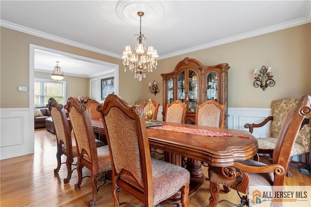 8 Adam Ct, Monroe, NJ 08831 - dining space featuring crown molding, wainscoting, a chandelier, light wood-type flooring, and a decorative wall