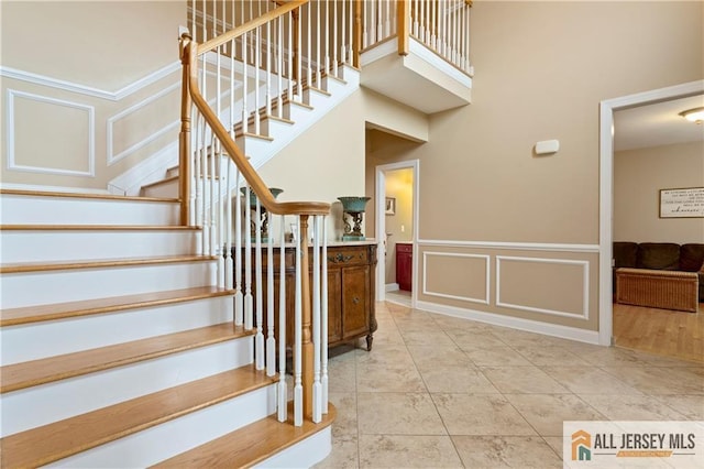 8 Adam Ct, Monroe, NJ 08831 - staircase featuring a decorative wall, tile patterned flooring, and wainscoting
