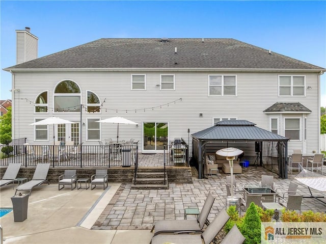 8 Adam Ct, Monroe, NJ 08831 - back of property with a gazebo, a patio area, a chimney, a shingled roof, and a wooden deck