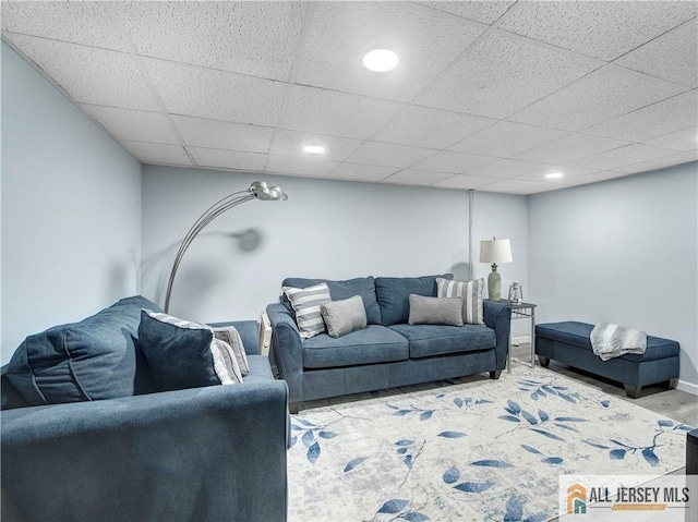 living room with a paneled ceiling, baseboards, and recessed lighting