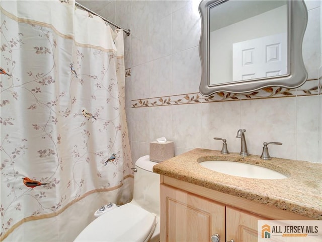 full bathroom with a shower with shower curtain, tile walls, toilet, and vanity