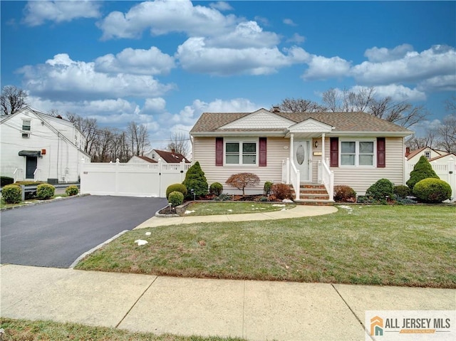 bungalow-style home with aphalt driveway, roof with shingles, a gate, fence, and a front yard