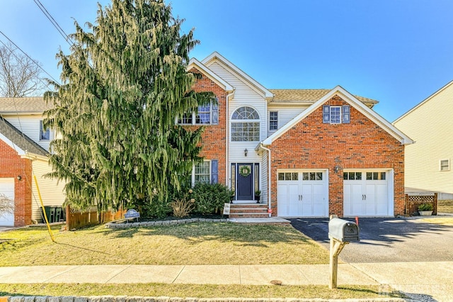 view of front facade with a front lawn, a garage, brick siding, and driveway