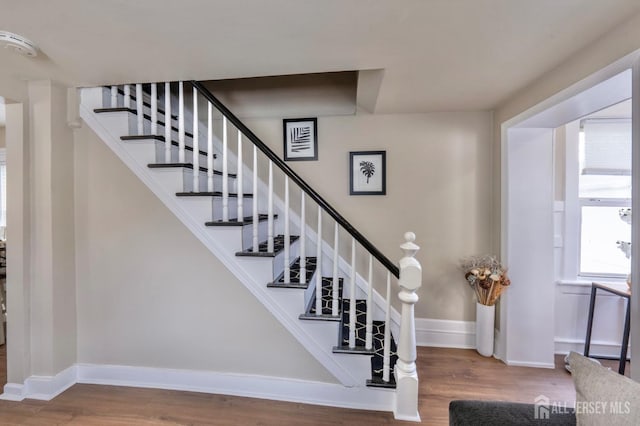 staircase with wood finished floors and baseboards