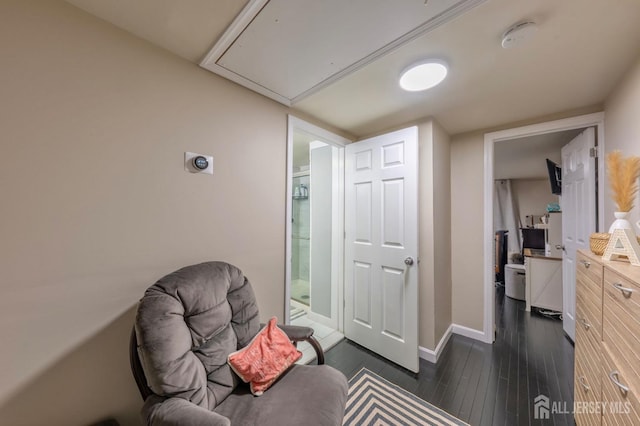 living area with attic access, dark wood-style flooring, and baseboards