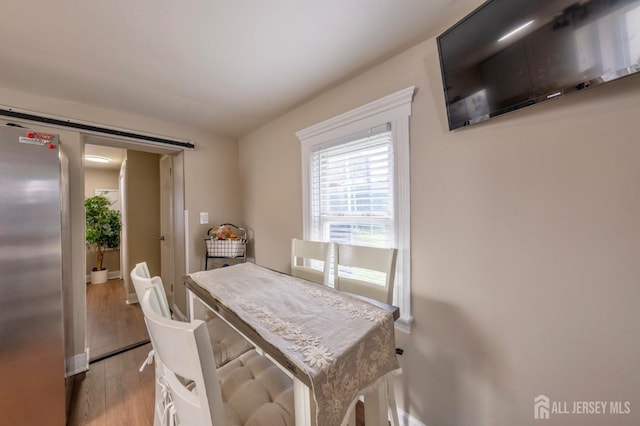dining area with light wood-style floors and baseboards