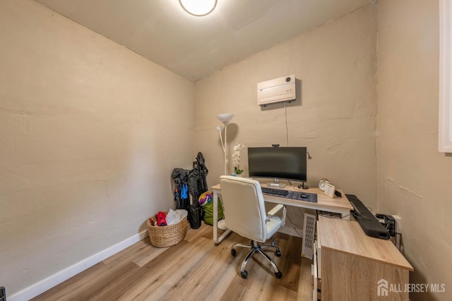 office with light wood finished floors, an AC wall unit, vaulted ceiling, and baseboards