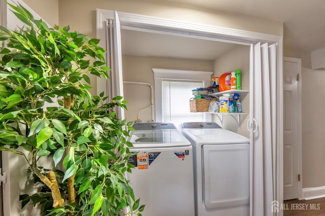 laundry area with washer and clothes dryer, wood finished floors, and laundry area