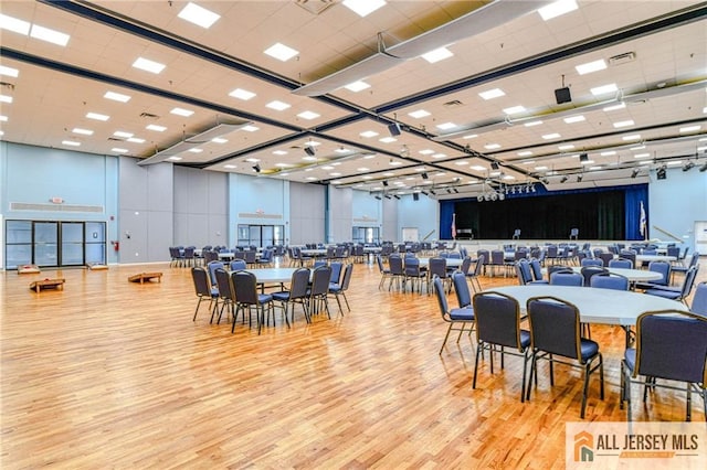 dining room with a high ceiling and light hardwood / wood-style flooring