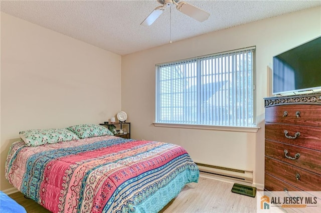 bedroom featuring ceiling fan, hardwood / wood-style floors, a textured ceiling, and a baseboard radiator