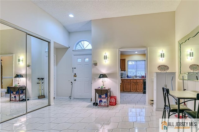 tiled foyer featuring a towering ceiling and a textured ceiling