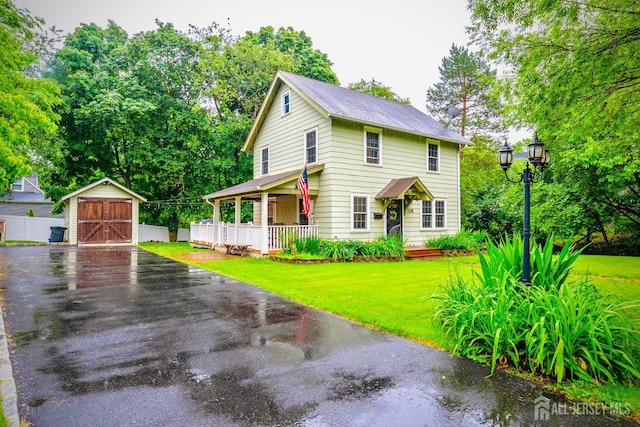 328 John St, Bound Brook, NJ 08805 - colonial inspired home featuring a porch, a front yard, a detached garage, a storage unit, and view of scattered trees