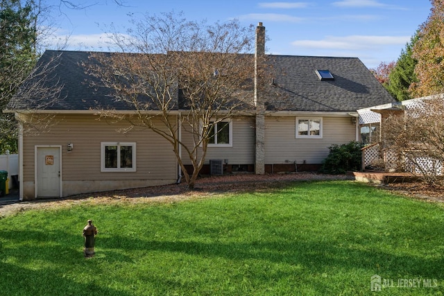 back of house with a lawn, central AC, and roof with shingles