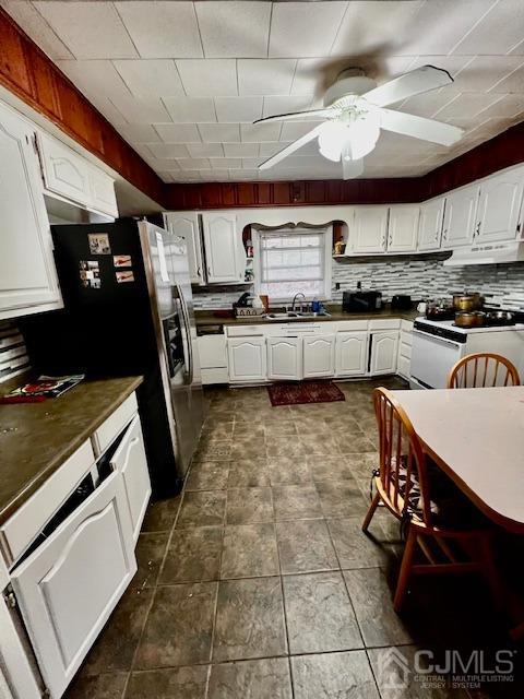 kitchen with tasteful backsplash, sink, white cabinets, and white appliances