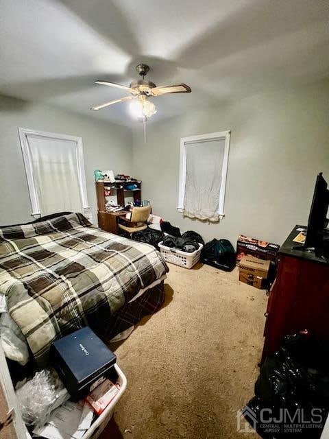 bedroom featuring ceiling fan and carpet