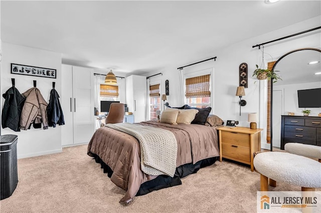 bedroom featuring light colored carpet and baseboards