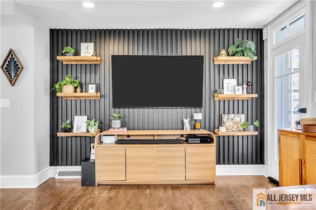 living area featuring recessed lighting, baseboards, light wood-style flooring, and an accent wall