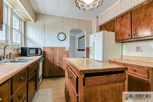 31 Lehigh Ave, Edison, NJ 08837 - kitchen with wallpapered walls, white refrigerator with ice dispenser, butcher block countertops, stainless steel microwave, and arched walkways