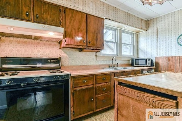 31 Lehigh Ave, Edison, NJ 08837 - kitchen featuring gas stove, wallpapered walls, under cabinet range hood, stainless steel microwave, and light countertops