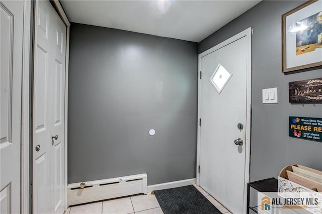tiled foyer entrance featuring baseboard heating and baseboards
