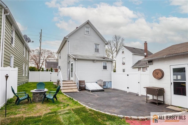 back of property featuring a patio area, an outdoor fire pit, and entry steps
