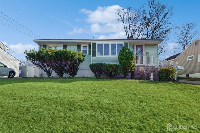 view of front of house featuring a storage unit and a front lawn