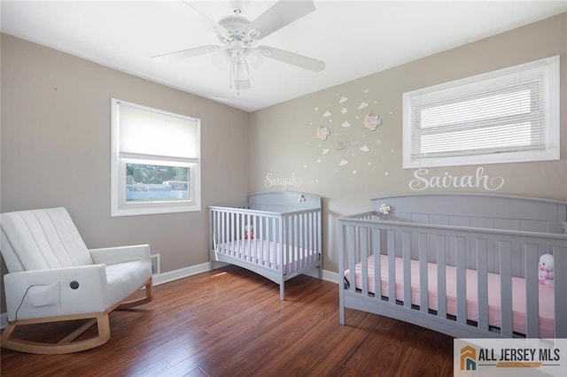 63 W Iselin Pkwy, Iselin, NJ 08830 - bedroom featuring multiple windows, wood finished floors, ceiling fan, and a crib