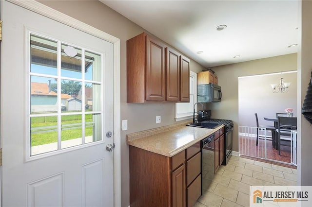 63 W Iselin Pkwy, Iselin, NJ 08830 - kitchen featuring black appliances, a chandelier, light countertops, light tile patterned flooring, and brown cabinets