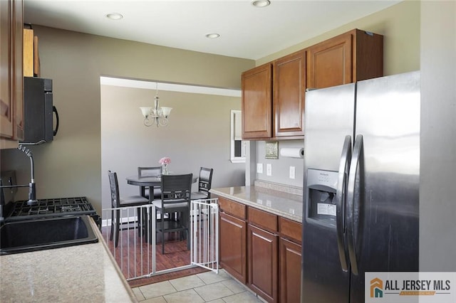 63 W Iselin Pkwy, Iselin, NJ 08830 - kitchen with stainless steel fridge, black microwave, light countertops, a chandelier, and brown cabinets