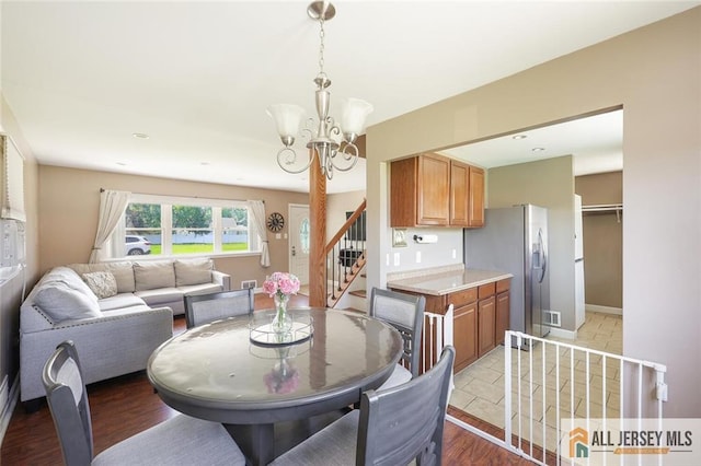 63 W Iselin Pkwy, Iselin, NJ 08830 - dining area featuring a chandelier, stairway, and light wood-type flooring