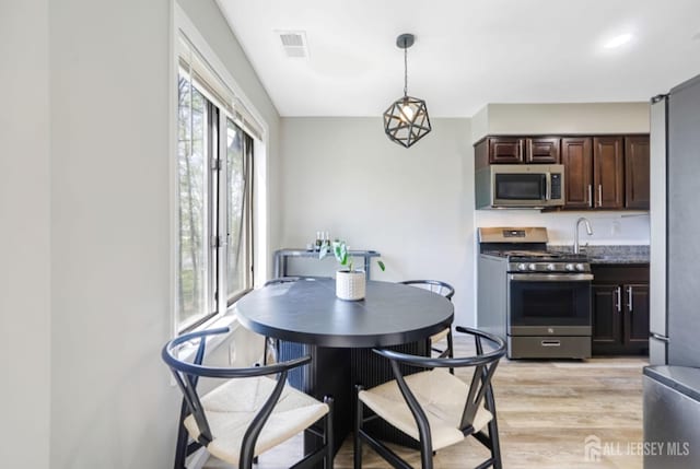 dining area featuring visible vents and light wood-style flooring