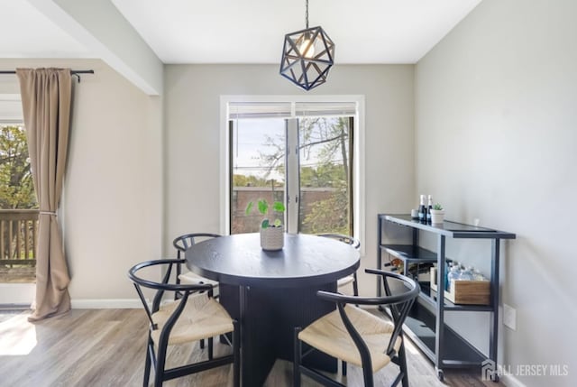dining area with baseboards and wood finished floors