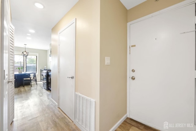 hall with recessed lighting, baseboards, visible vents, and light wood-style floors