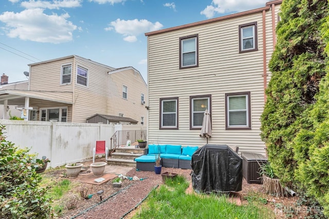 rear view of house featuring fence, central AC unit, and an outdoor living space