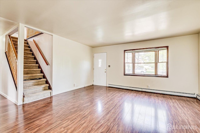 137 Grand Ave, Iselin, NJ 08830 - foyer entrance featuring baseboard heating, stairs, wood finished floors, and baseboards
