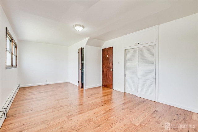 137 Grand Ave, Iselin, NJ 08830 - unfurnished bedroom featuring a baseboard heating unit, light wood finished floors, a closet, and baseboards