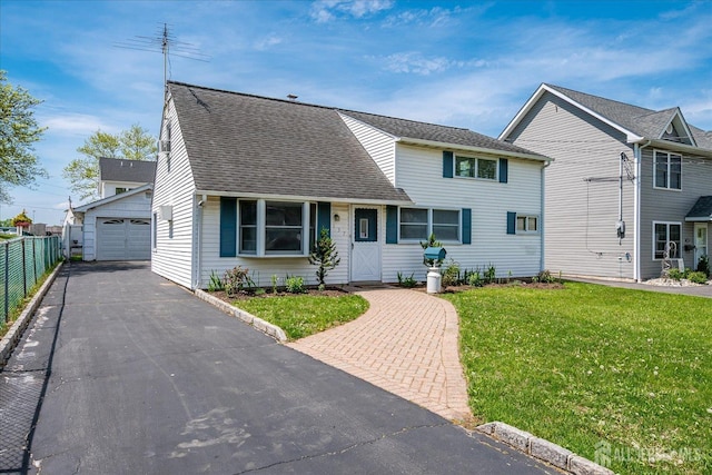 view of front of home featuring a detached garage, roof with shingles, and driveway
