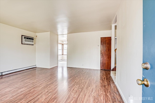 137 Grand Ave, Iselin, NJ 08830 - spare room with a wall unit AC, wood finished floors, a baseboard heating unit, baseboard heating, and baseboards