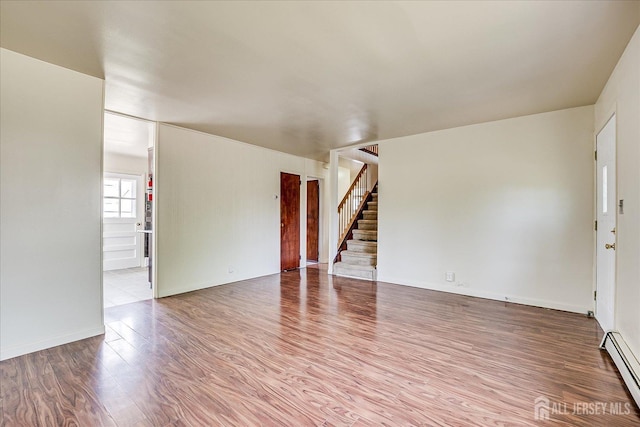 137 Grand Ave, Iselin, NJ 08830 - unfurnished room featuring a baseboard radiator, wood finished floors, and stairway